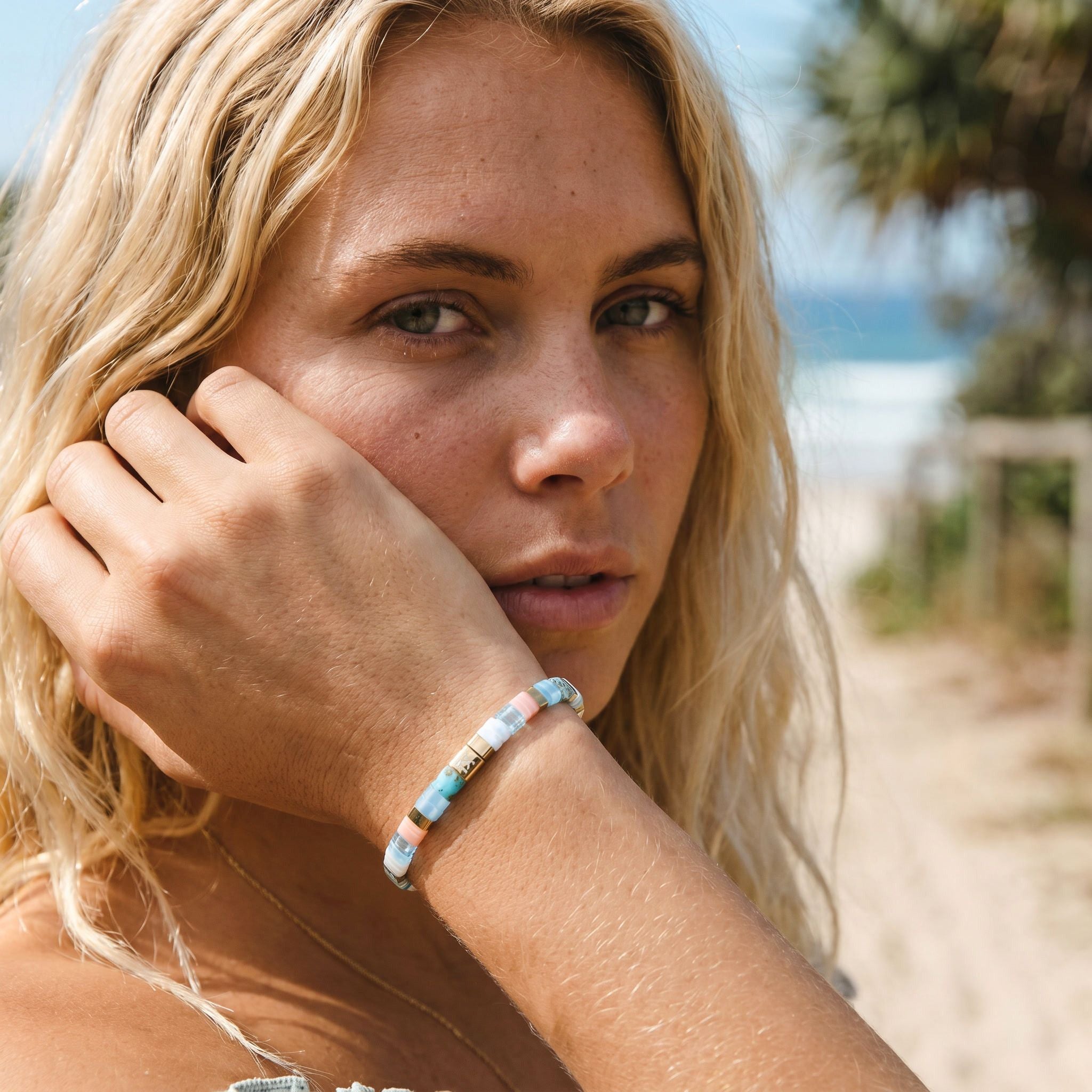 Woman with a bracelet on her wrist against a beach background