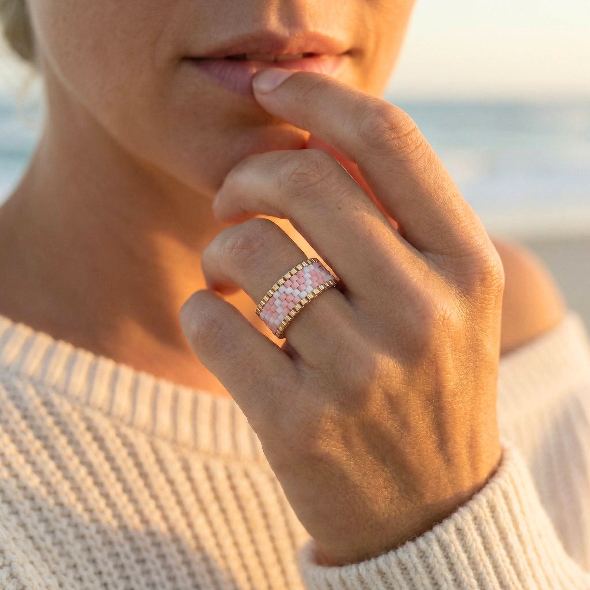 Close-up of a hand wearing a ring with a scenic background