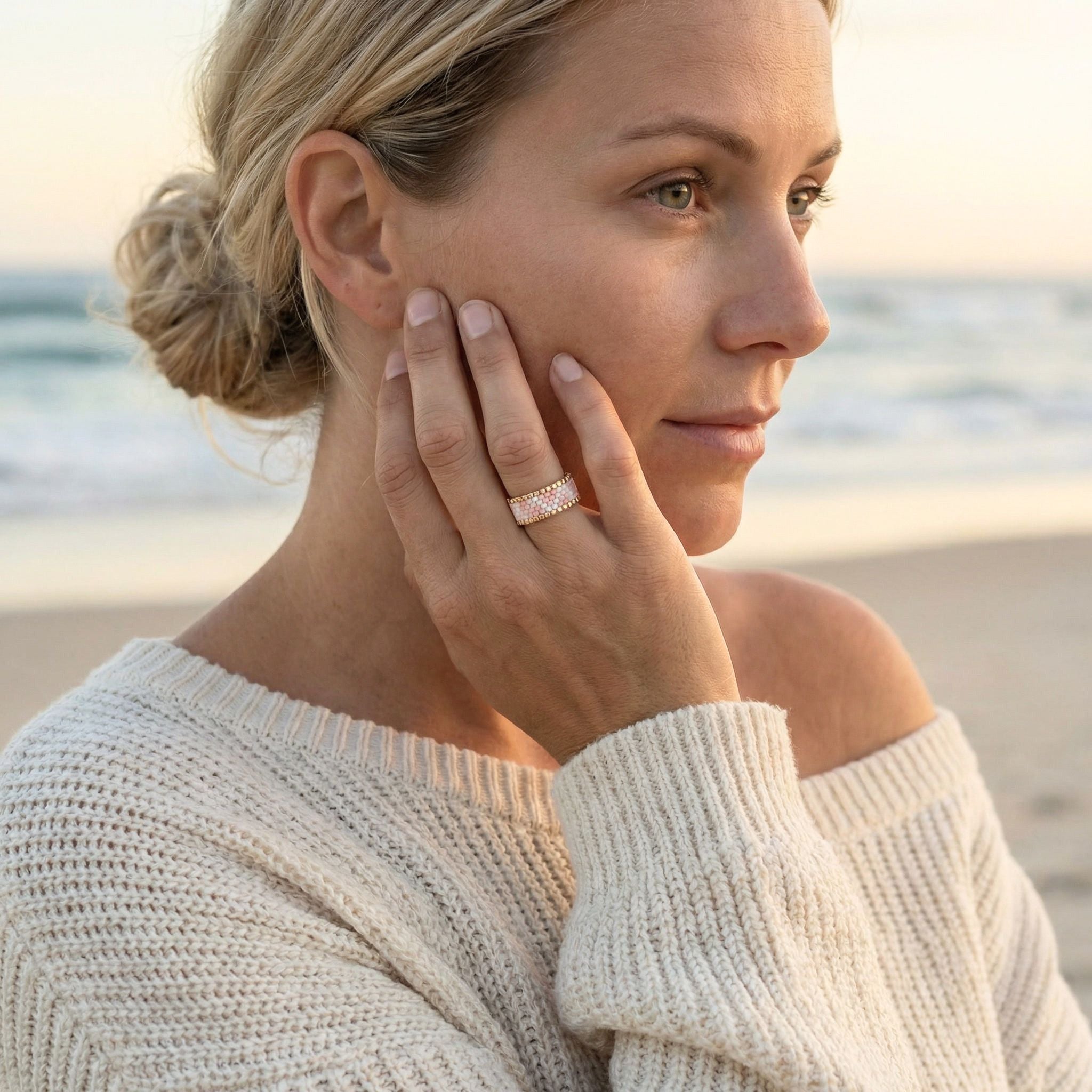 Woman on a beach wearing a ring, with a blurred background