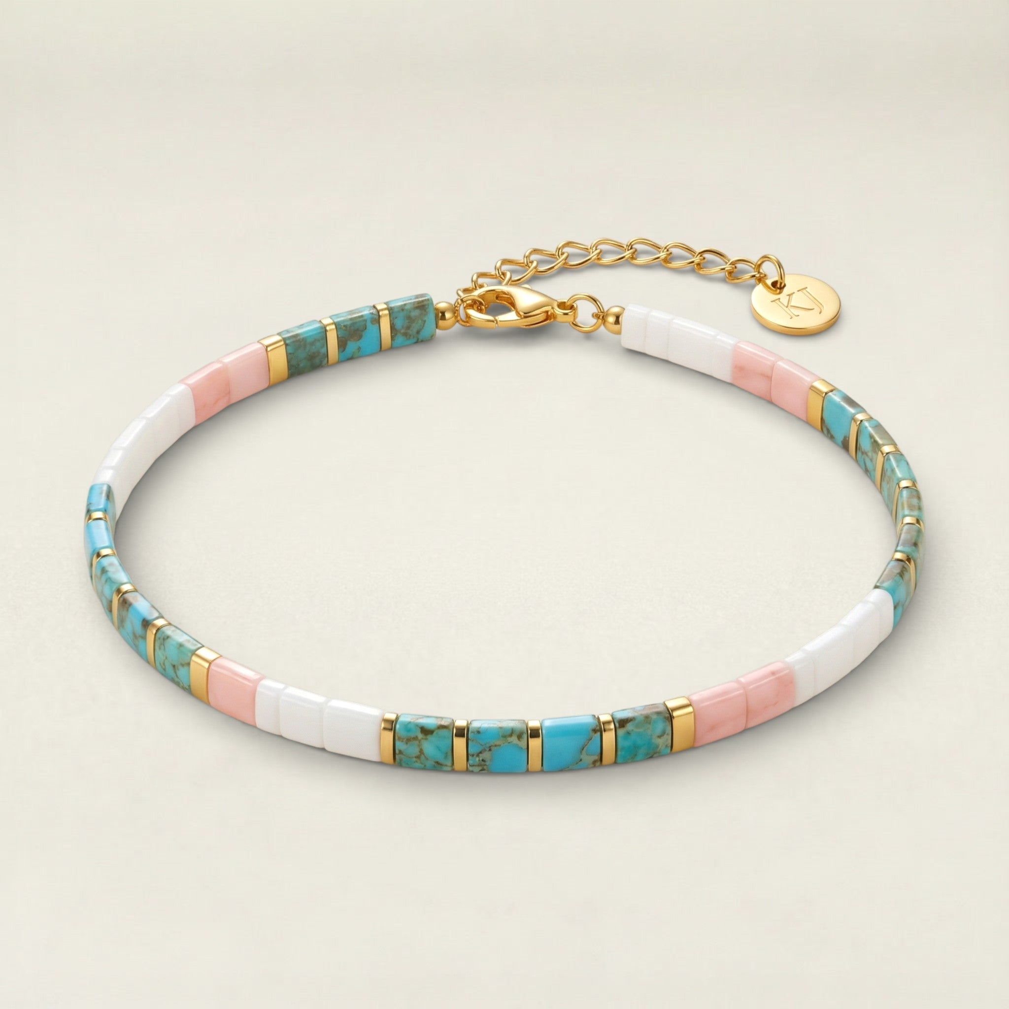 Multicolored beaded bracelet with gold accents on a beige background