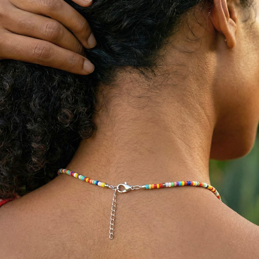 Close-up of a person wearing a colorful beaded necklace with a blurred background