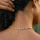 Close-up of a person wearing a colorful beaded necklace with a blurred background