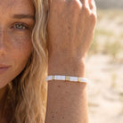 Woman wearing a bracelet with a blurred natural background