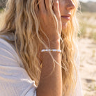 Close-up of a person wearing a thin bracelet outdoors