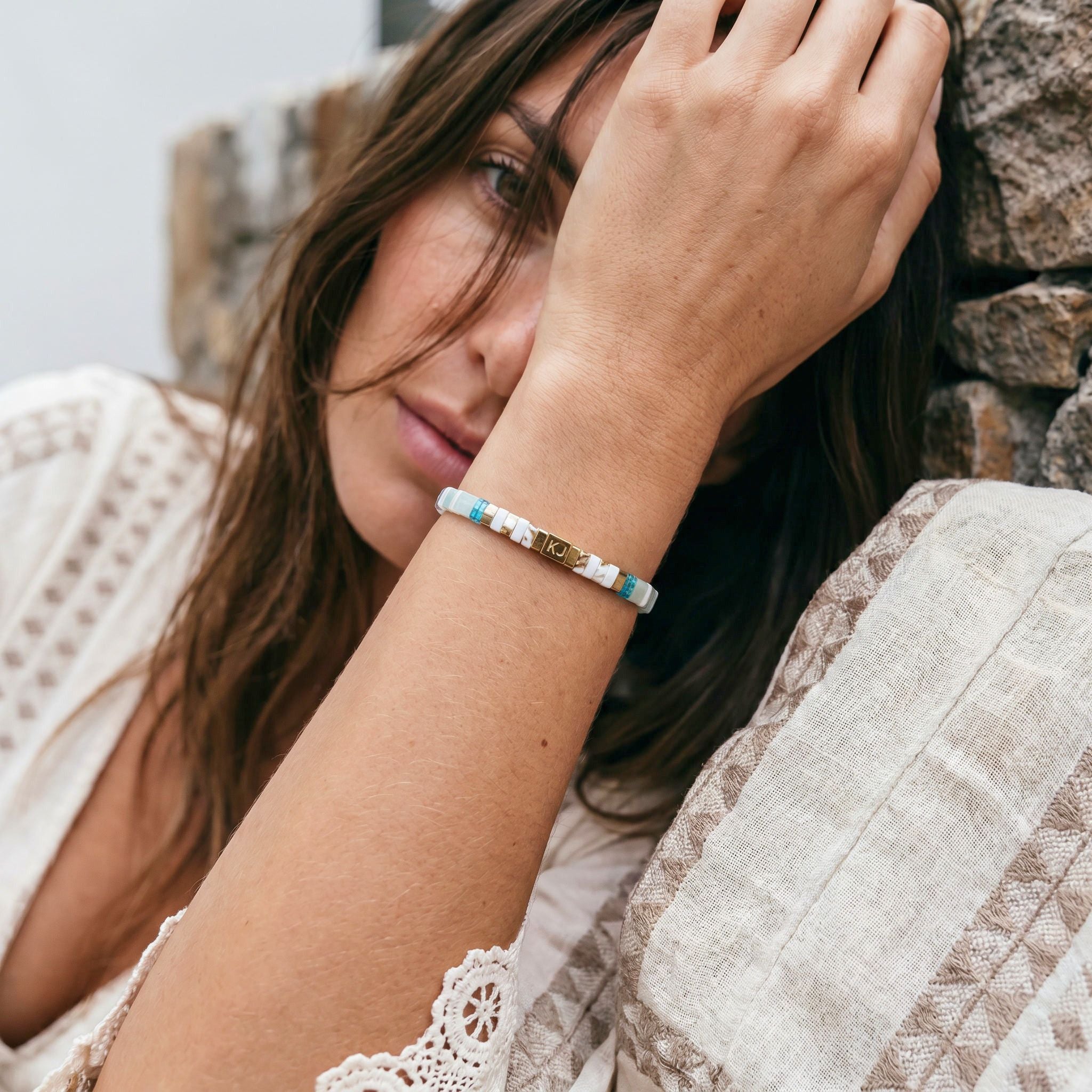 Woman wearing a bracelet with a stone wall background