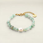 Bracelet with green beads and a gold clasp on a light background