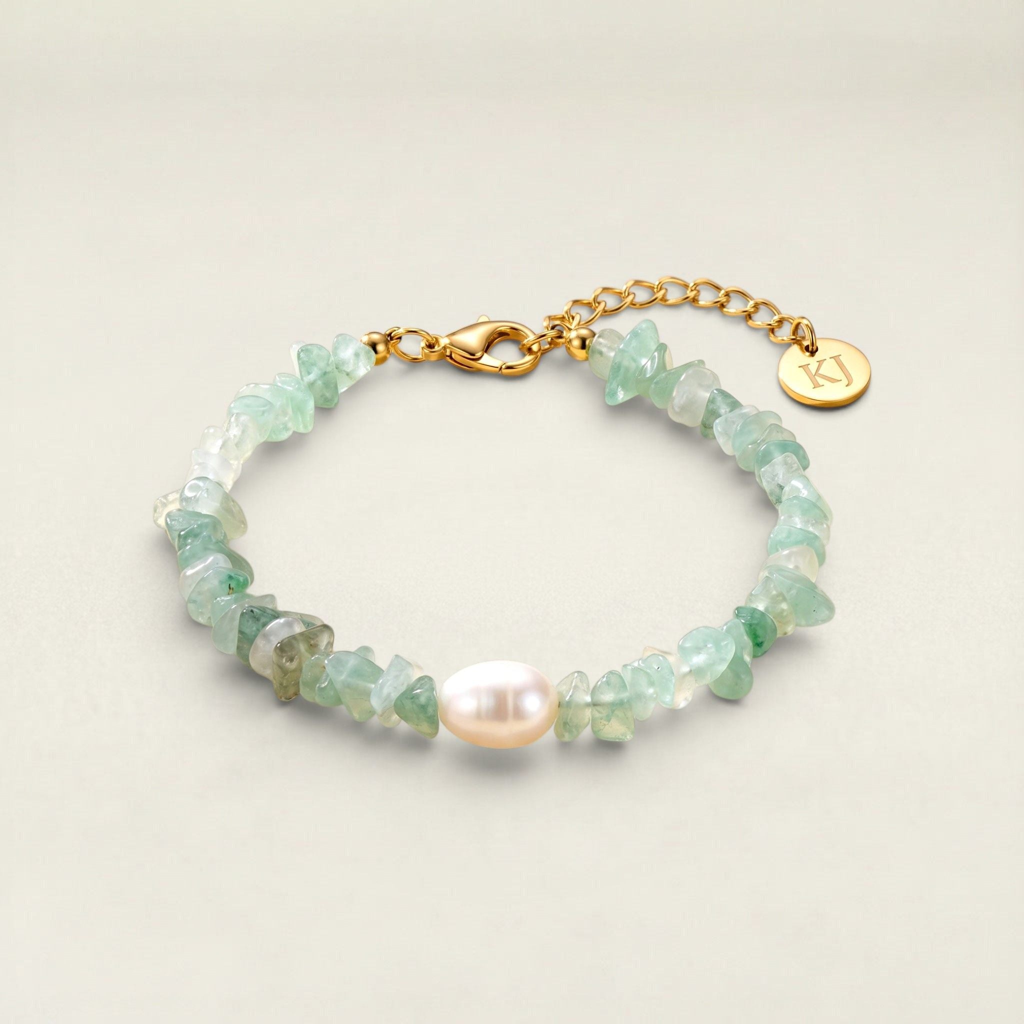 Bracelet with green beads and a gold clasp on a light background