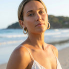 Woman on a beach with ocean and sky in the background