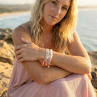 Woman in a pink dress with bracelets on a beach