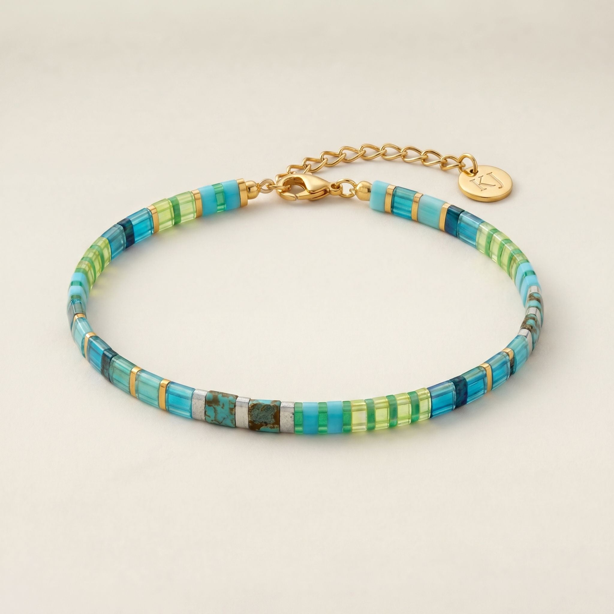 Multicolored beaded bracelet with gold clasp on a beige background