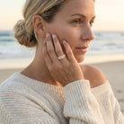 Woman on a beach wearing a ring, with a blurred background