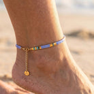 Anchored bracelet on a person's ankle with a beach background