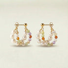 Pair of pearl and gemstone hoop earrings on a light background