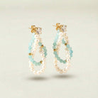 Pair of pearl and beaded hoop earrings on a light background