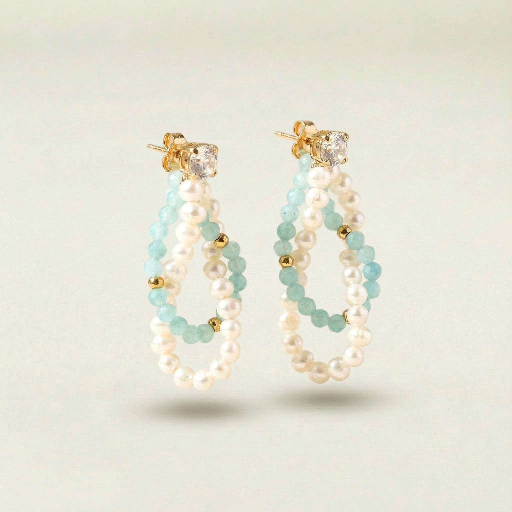 Pair of pearl and beaded hoop earrings on a light background