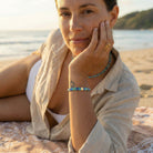 Woman sitting on a beach with a scenic background