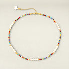 Necklace with colorful beads and white pearls on a light gray background