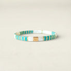 Bracelet with blue and gold stripes on a beige background