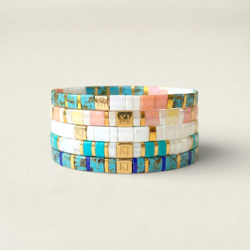 Stack of colorful mosaic bracelets on a light background