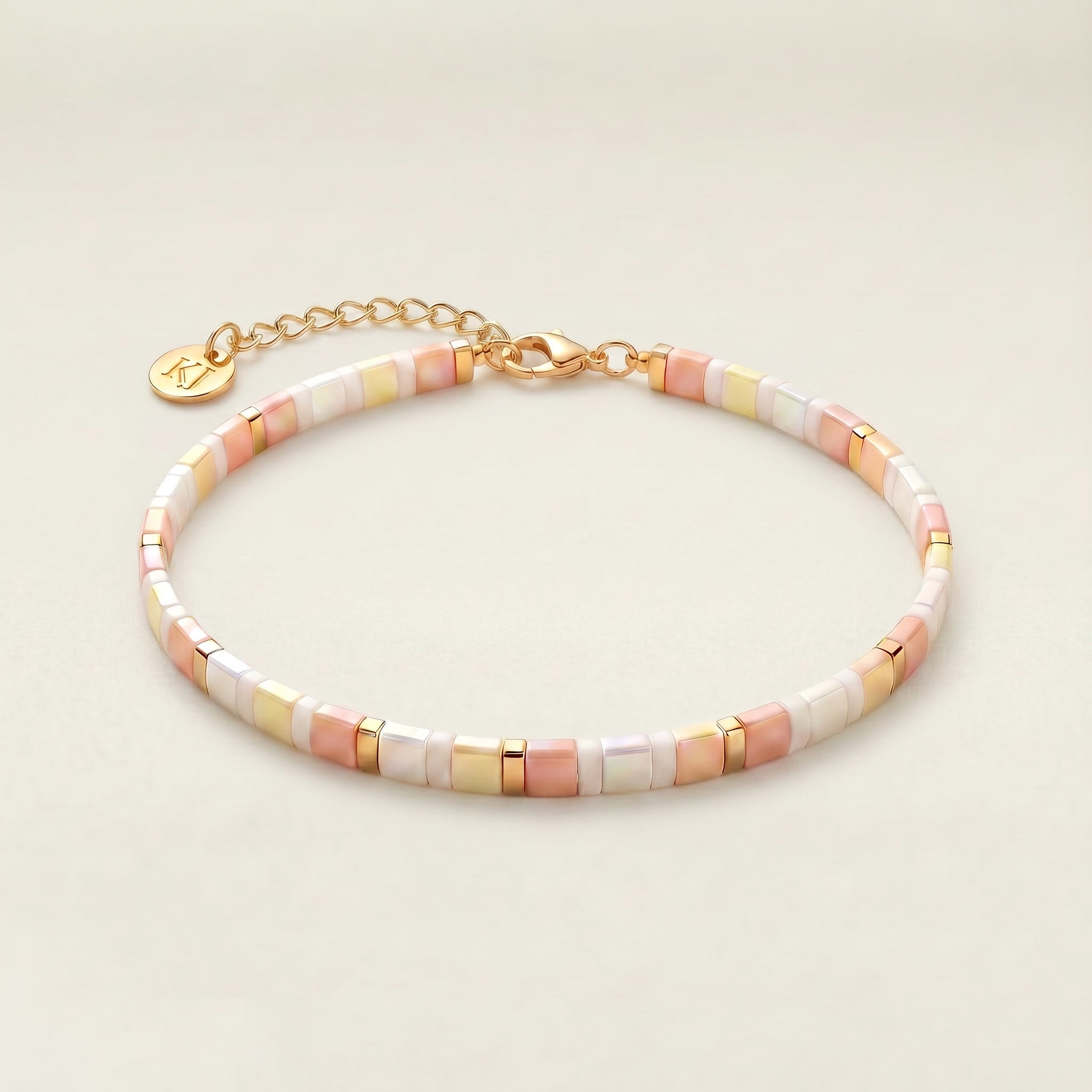 Multicolored beaded bracelet with gold chain on a light beige background