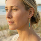 Woman wearing earrings with a beach background
