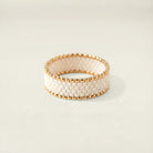 Gold and white beaded bracelet on a light background