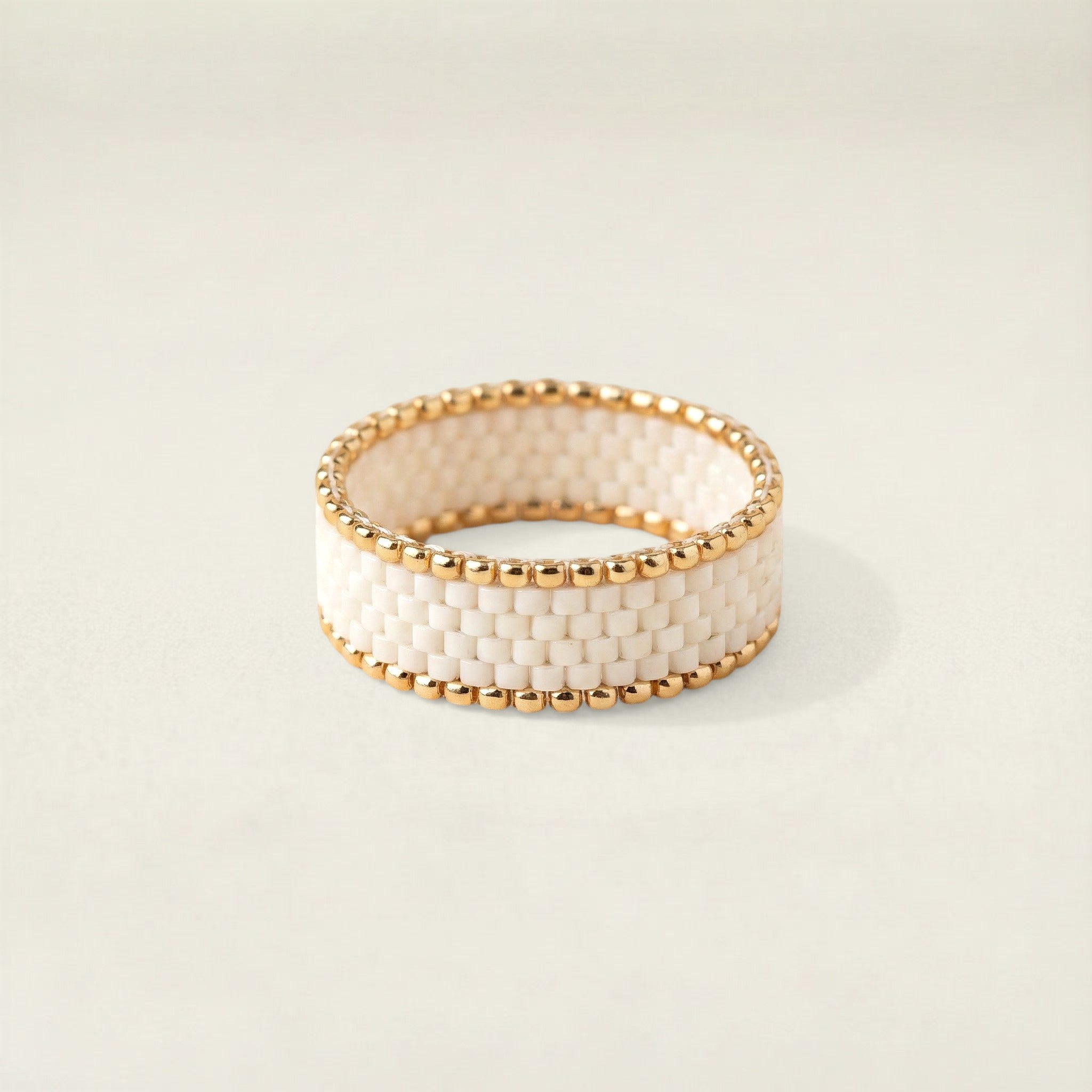 Gold and white beaded bracelet on a light background